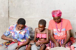 three women and children sitting on the ground